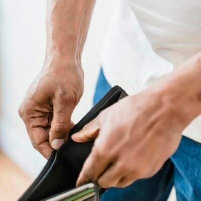 Close-up shot of hands holding an empty wallet, symbolizing financial stress.