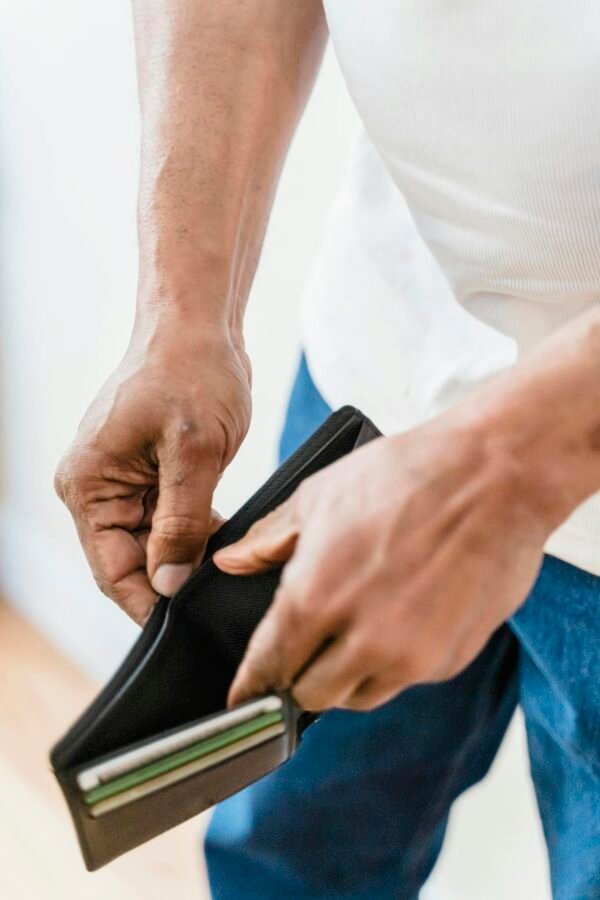 Close-up shot of hands holding an empty wallet, symbolizing financial stress.